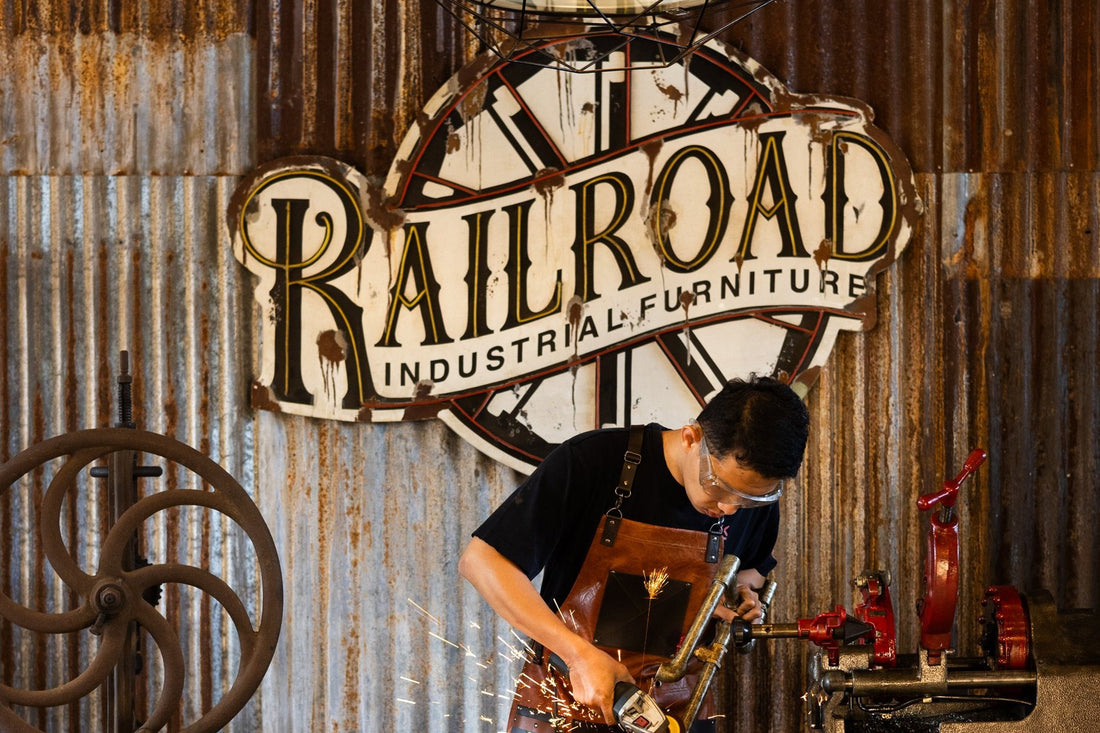 A Railroad maker grinding steel at the workbench under the Railroad sign